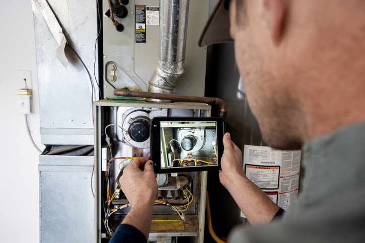 tech repairing a furnace system